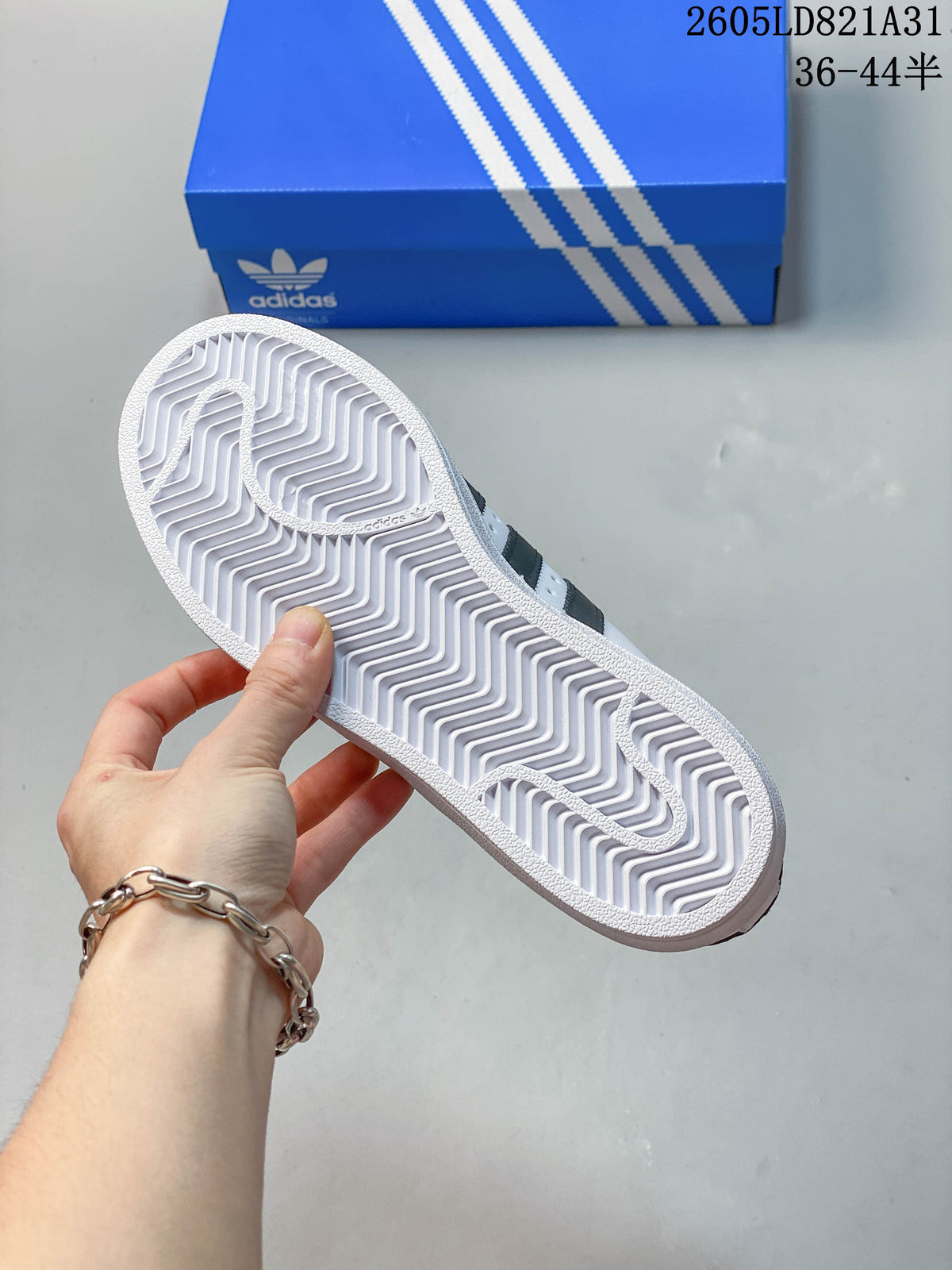 Underside of a white sneaker showing a patterned rubber outsole.