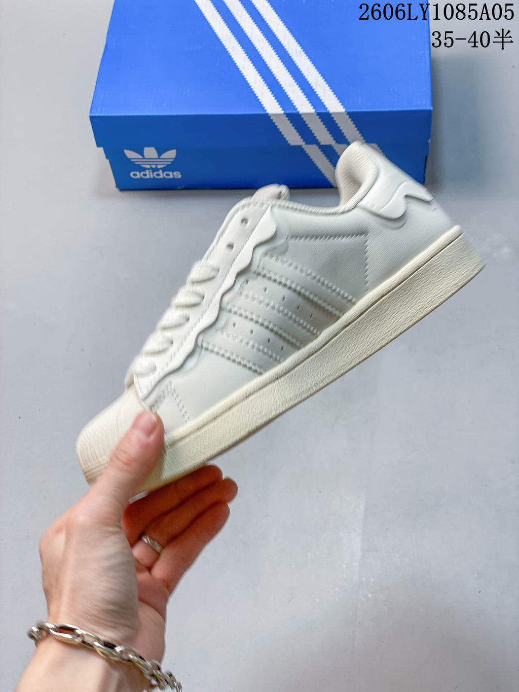 Side view of an off-white low-top sneaker with three-stripe detailing