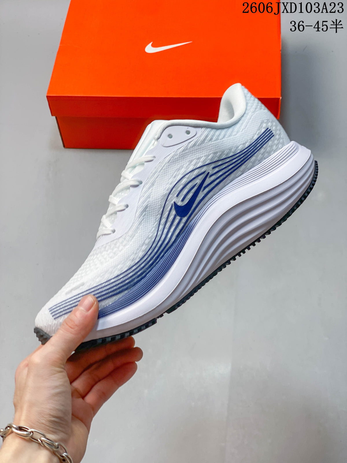Side view of a white running shoe with dark blue graphics and a sculpted midsole