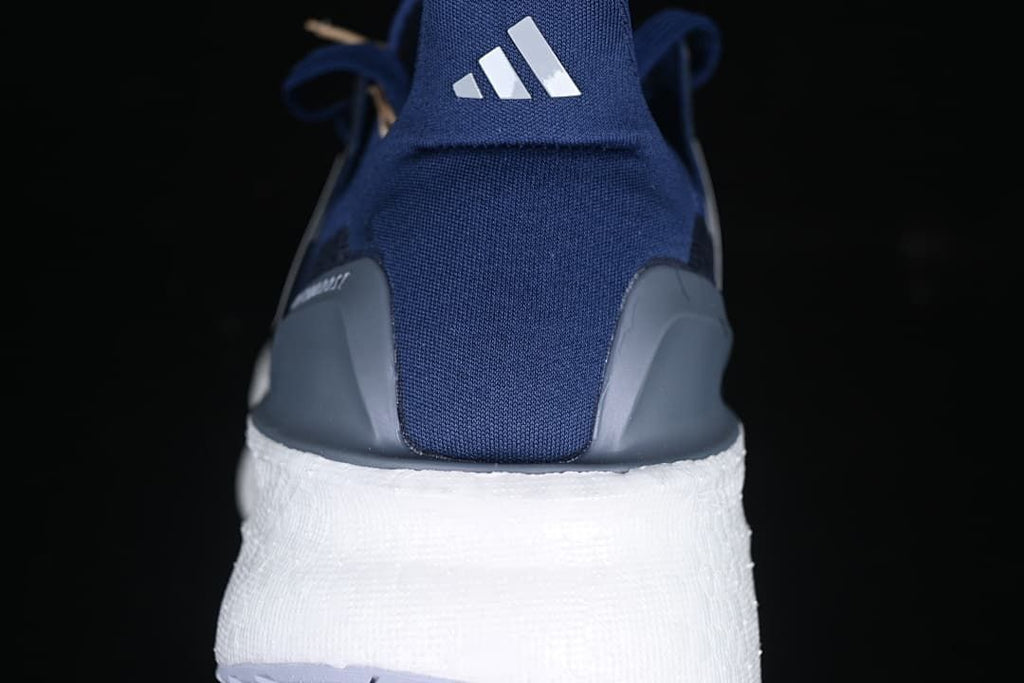 Rear view showing the blue heel, gray heel pieces, and white midsole.