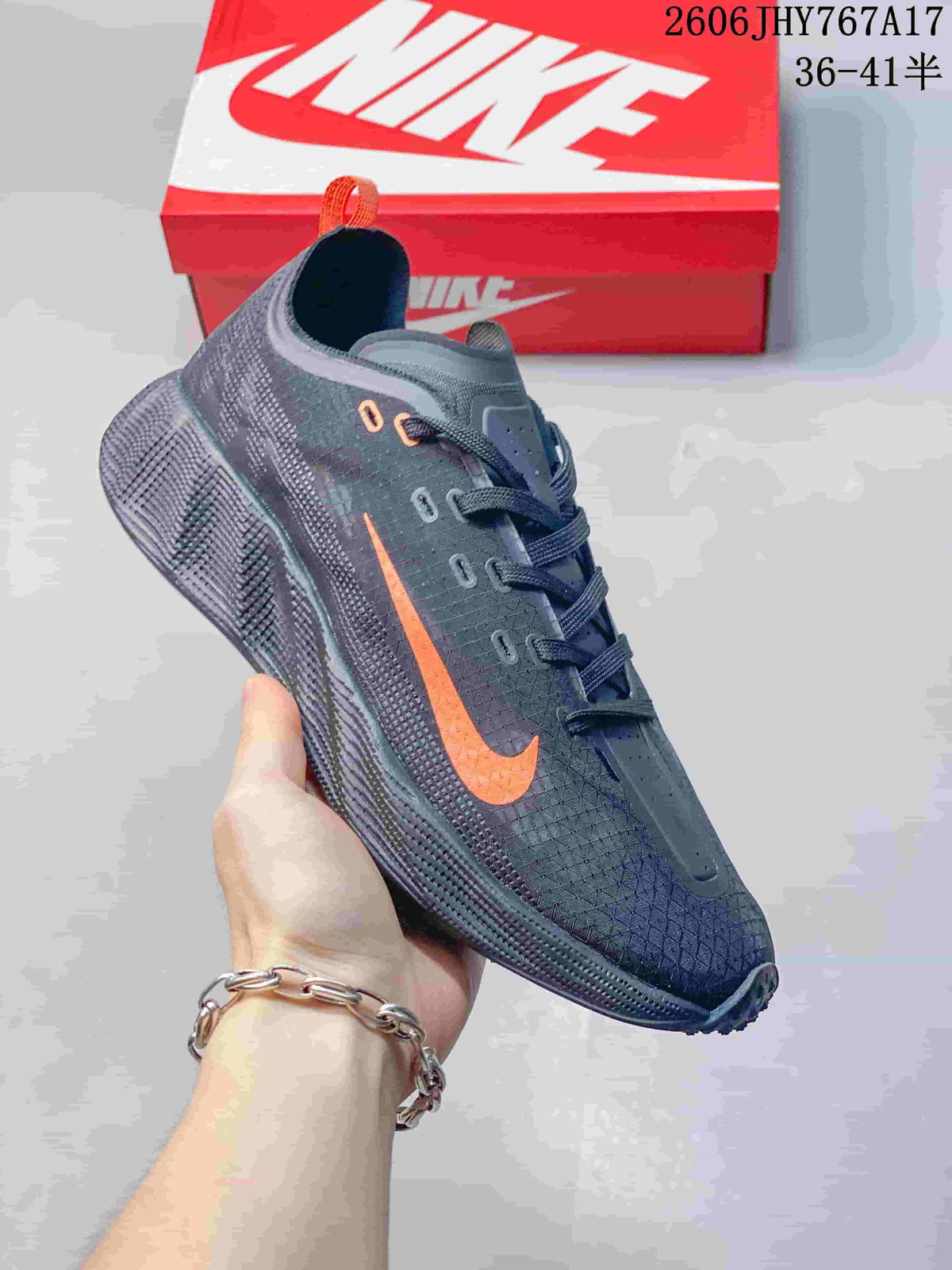 Angled side view of a dark gray Nike Ava Rover sneaker with orange accents and a textured sole.