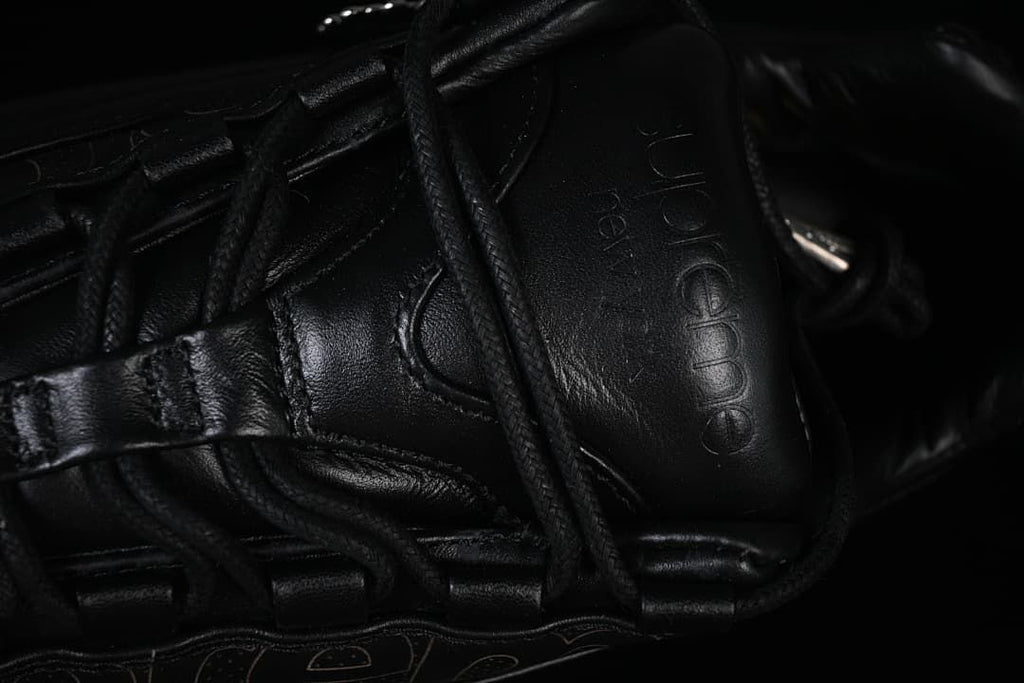 Close-up of the tongue, laces, and embossed Supreme branding