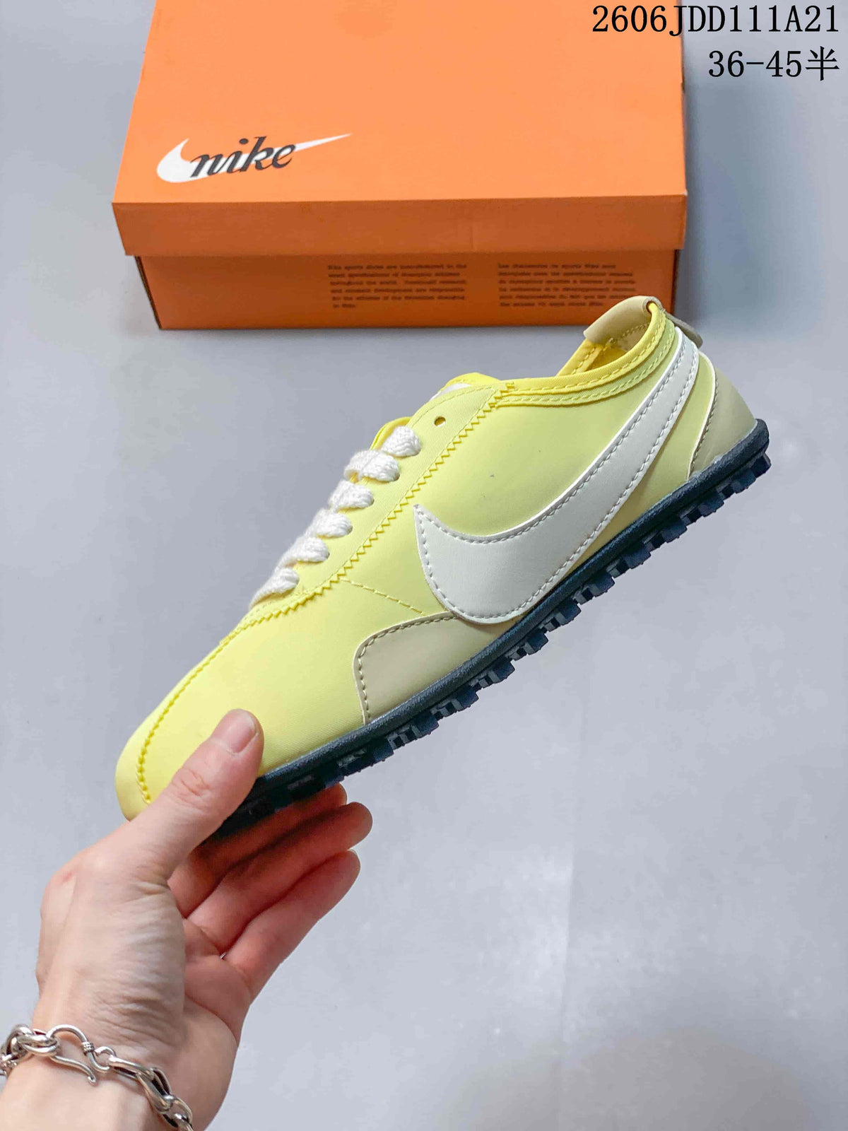 Side view of the pale yellow low-top sneaker with white Swoosh accents and dark outsole.