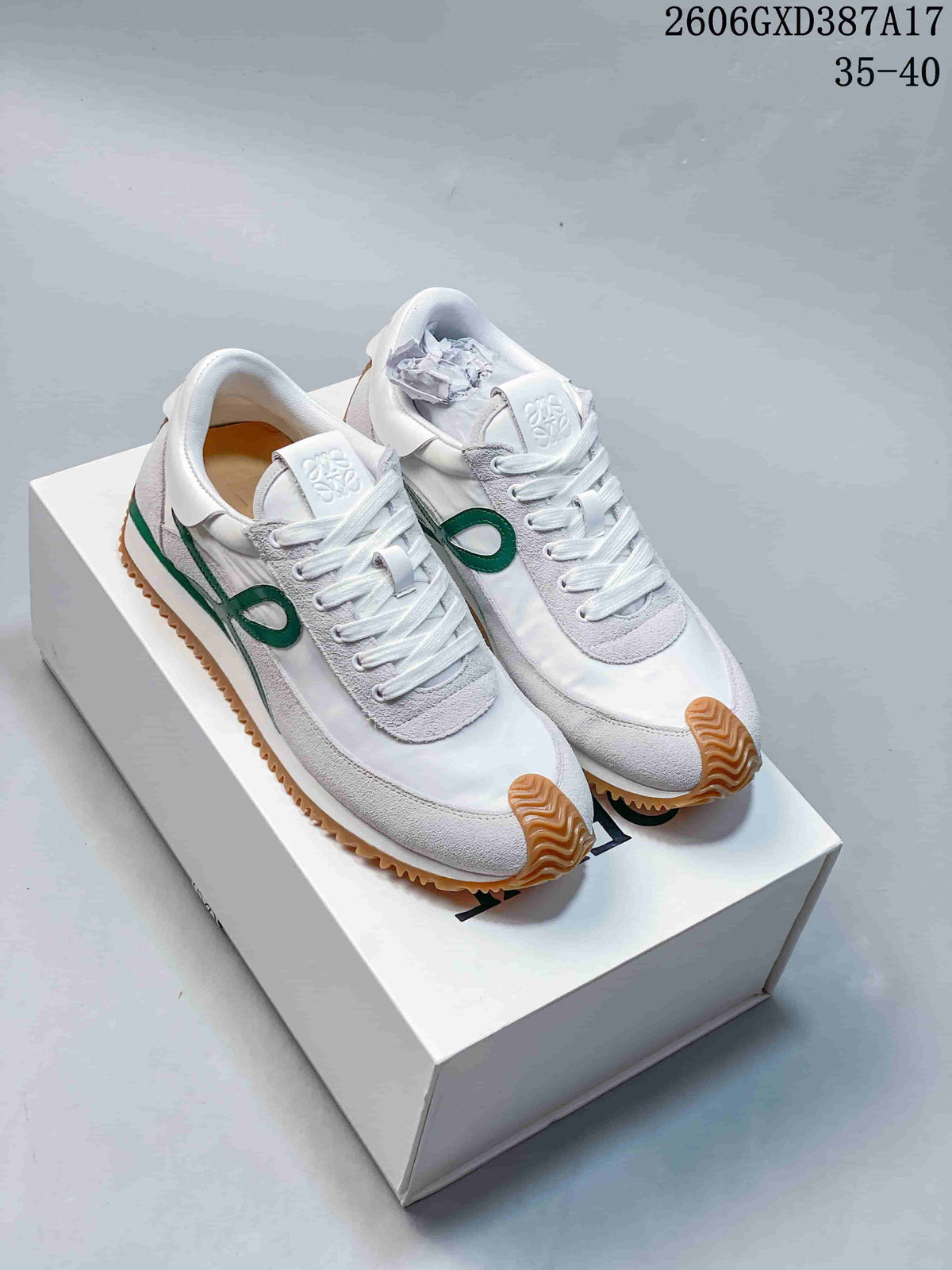 Pair of white and light gray low-top sneakers with green side detailing and gum-colored soles