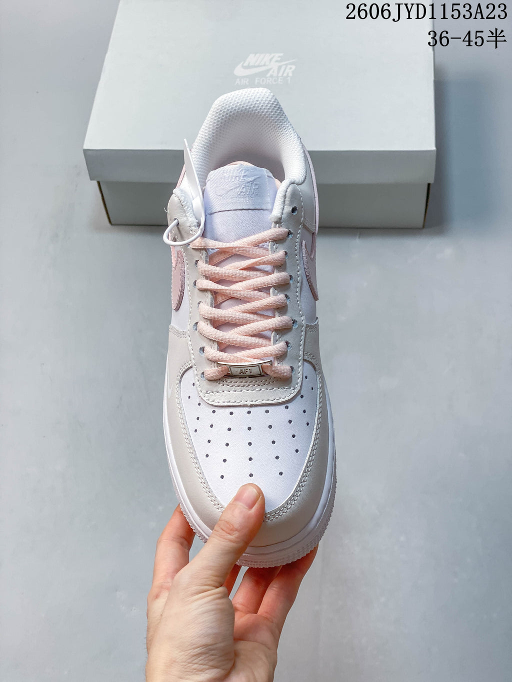 Front view showing perforated toe, pale pink laces, and lace tag