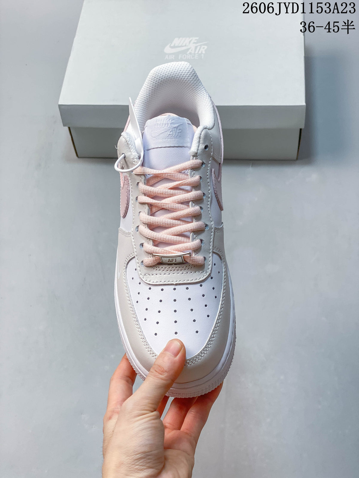 Front view showing perforated toe, pale pink laces, and lace tag