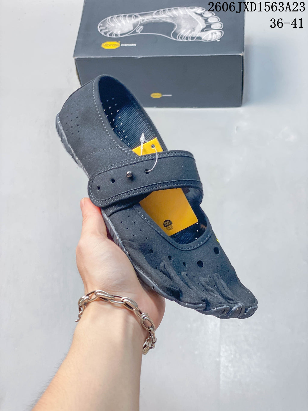 Angled view of a gray FiveFingers-style shoe with perforated upper and adjustable strap