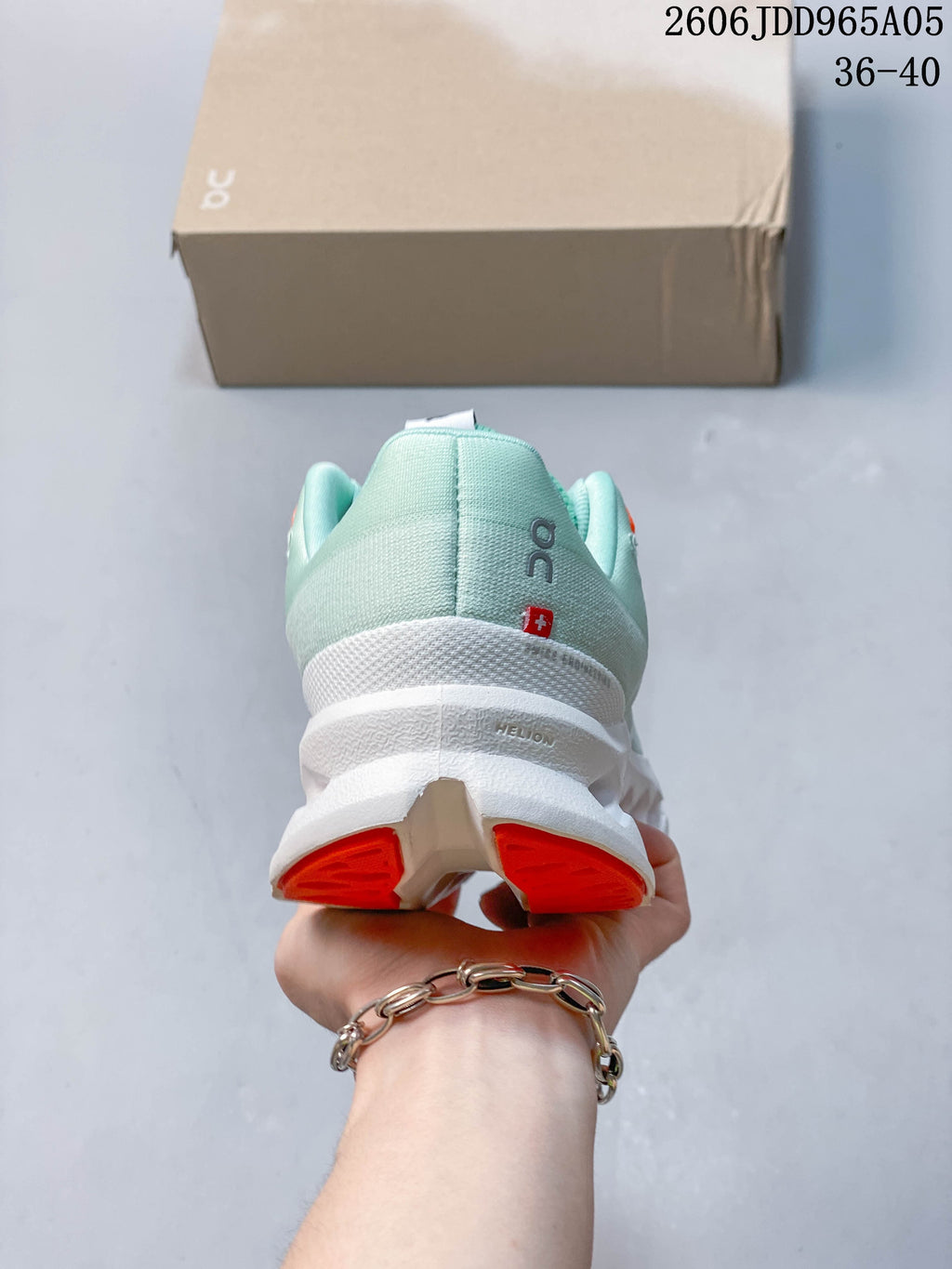 Rear view of the shoe with mint heel and orange outsole accents
