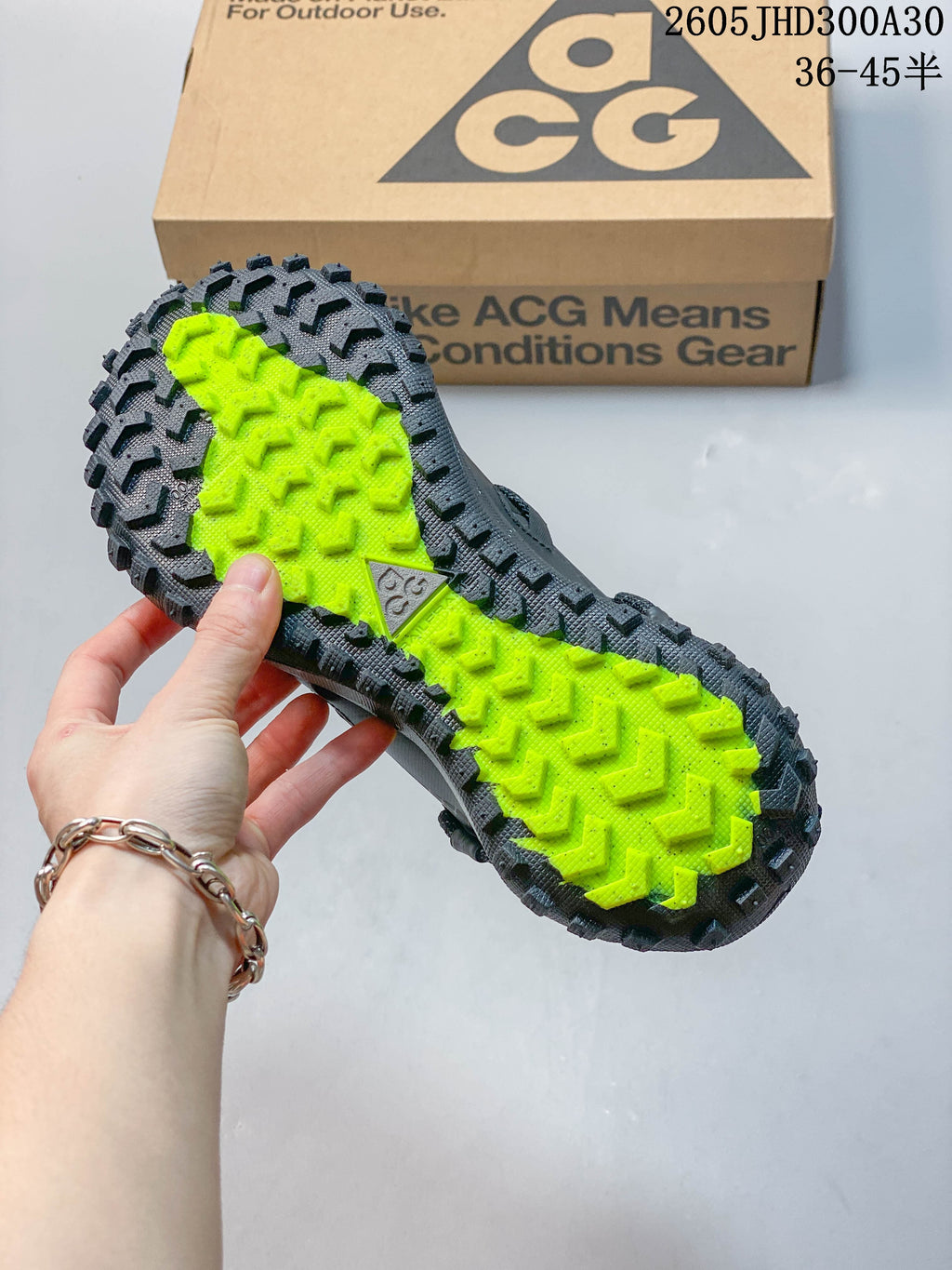 View of the shoe outsole with bright yellow-green center and deep tread