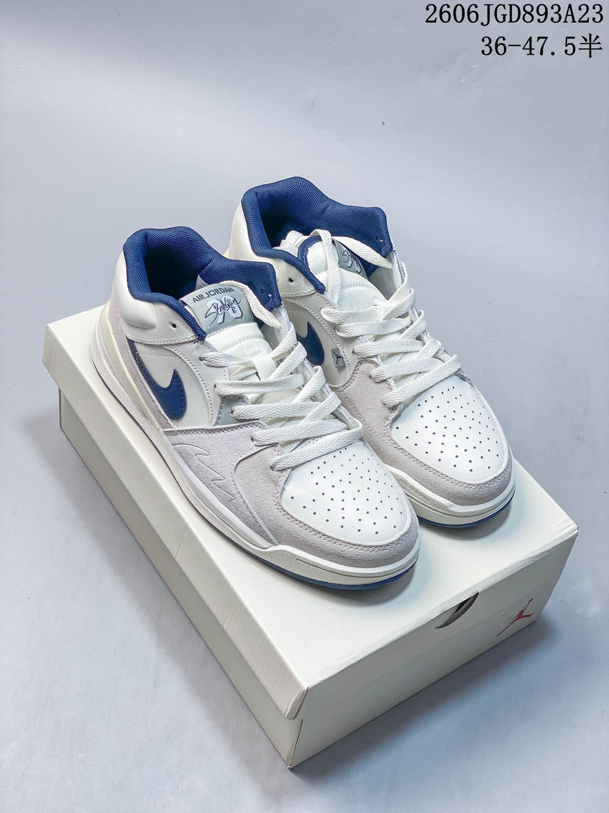 Pair of white Jordan Stadium 90 sneakers with blue accents and light gray overlays