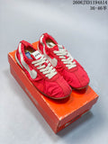 Pair of red Nike Jacquemus low-top sneakers with off-white accents on an orange shoebox