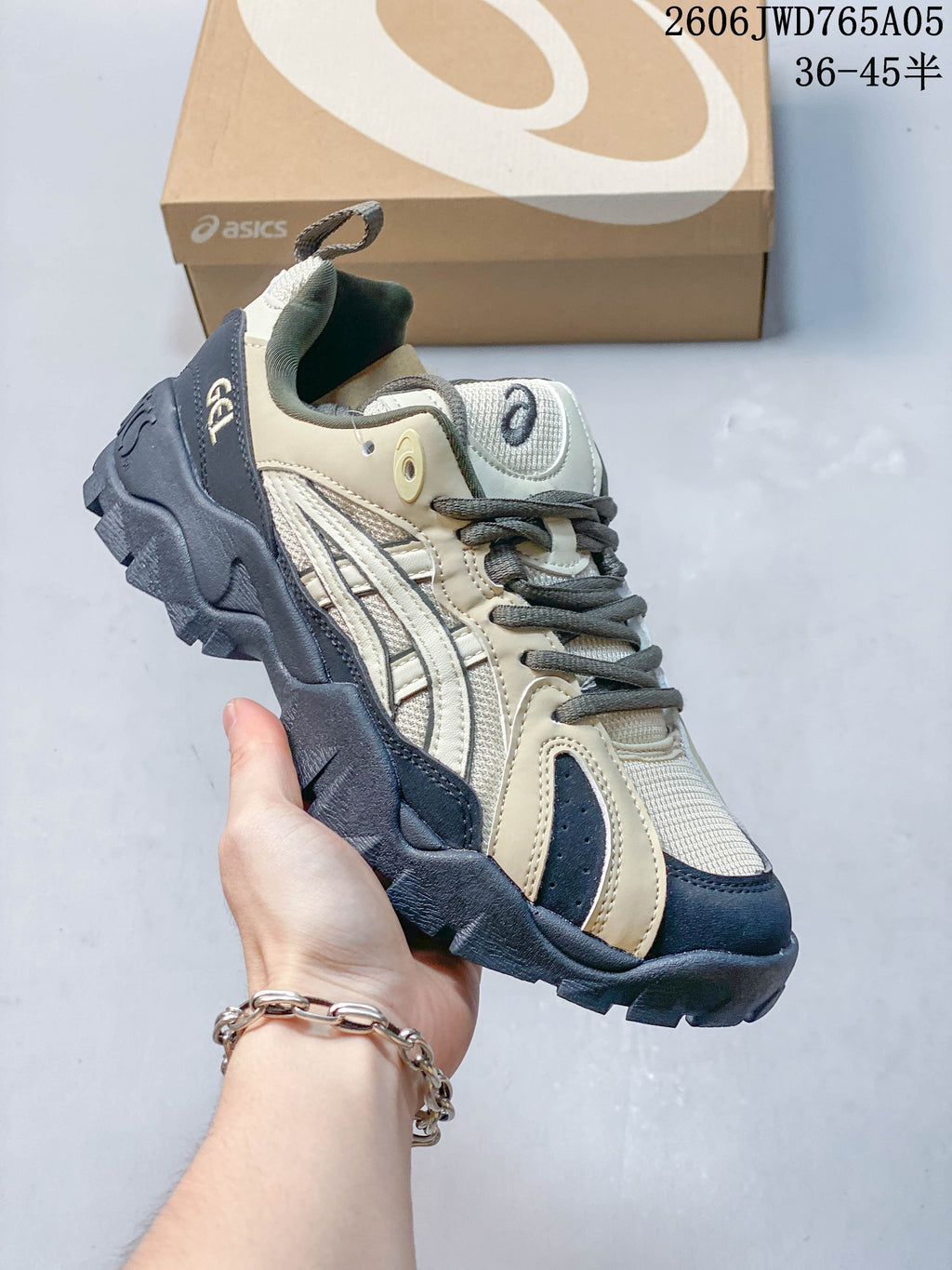 Cream, gray, and navy ASICS Gel-TRUCK sneaker with a sculpted treaded outsole.