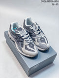 Pair of gray New Balance 1906R sneakers shown on a shoe box