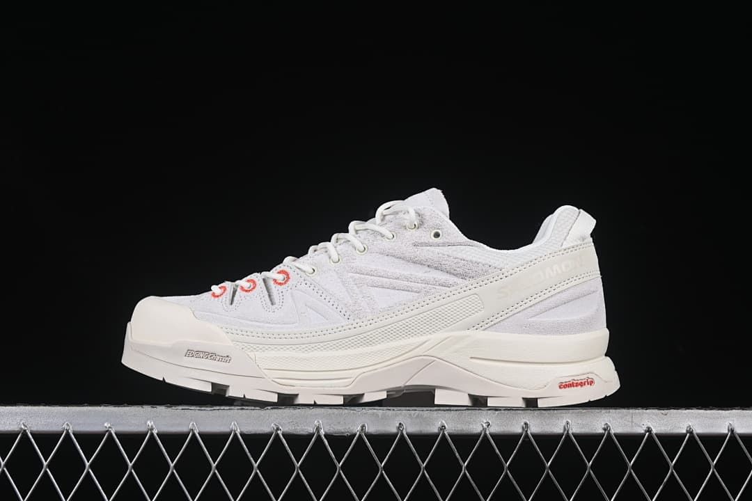 Side profile of the light-colored shoe with red accents