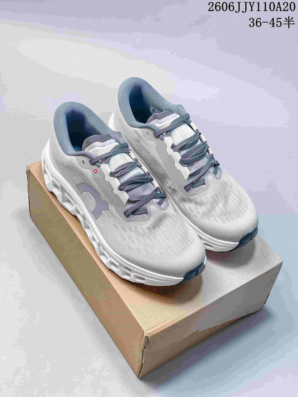 Pair of light gray On Cloudmonster 3 running shoes on a box