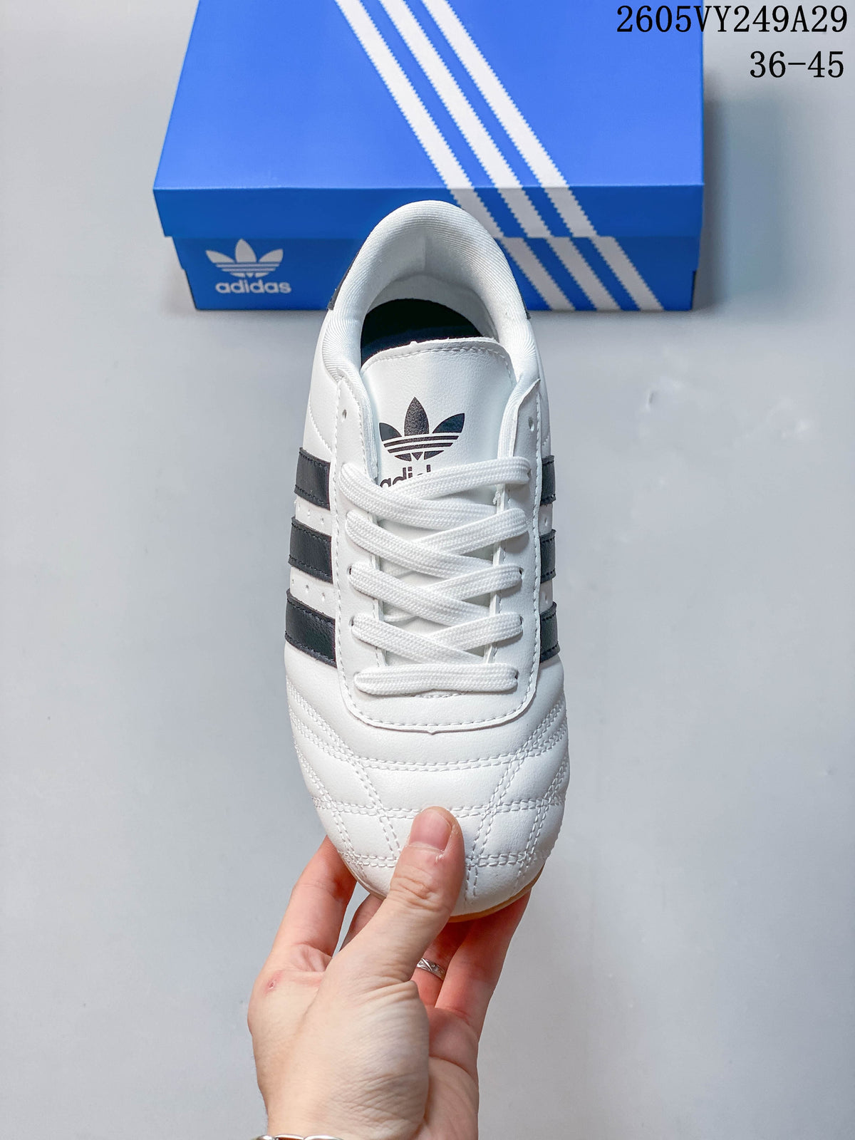 Top view of a white adidas Taekwondo sneaker with white laces and quilted toe stitching