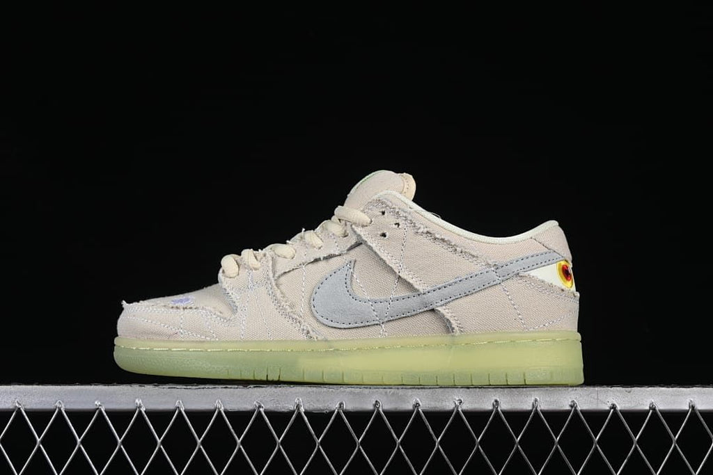 Side profile of a pale Nike SB Dunk Low with a gray Swoosh and translucent light-green outsole