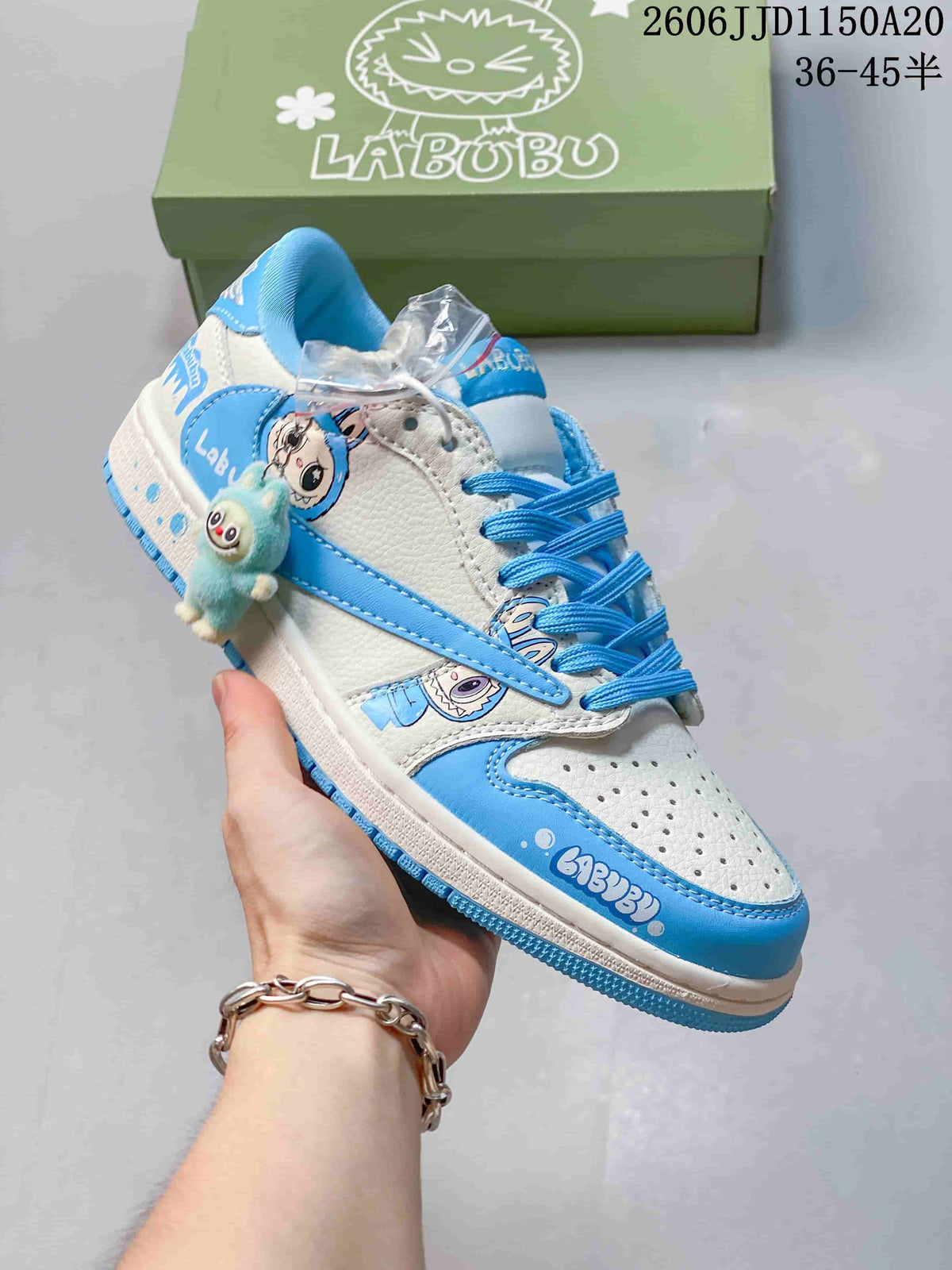 Angled side view of the white and blue sneaker with character graphics and a plush charm.