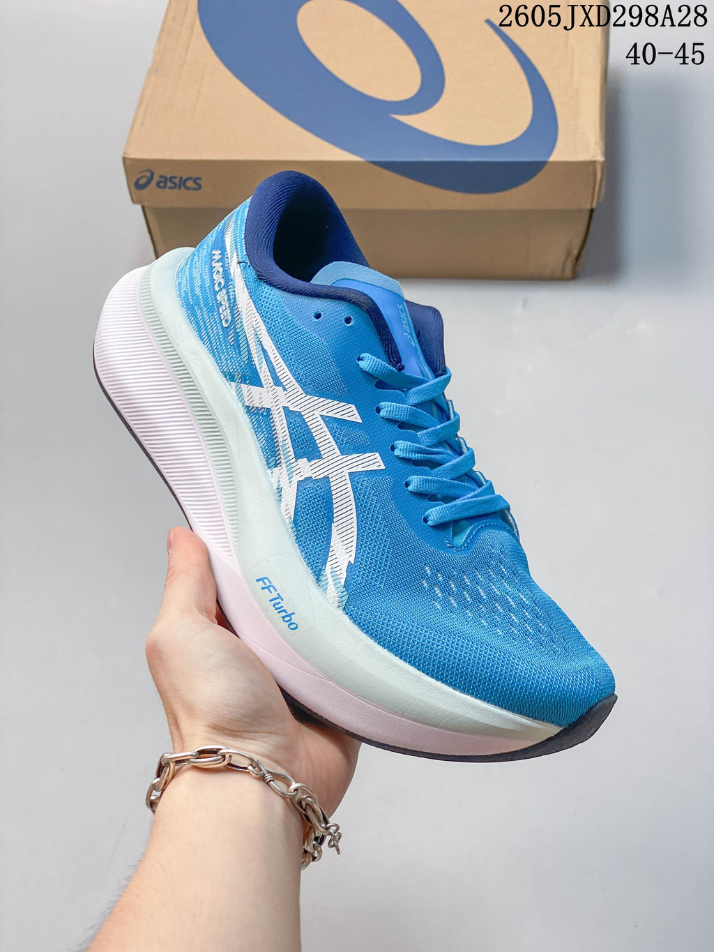 Angled side view showing the blue upper and layered sole of an ASICS Magic Speed 4