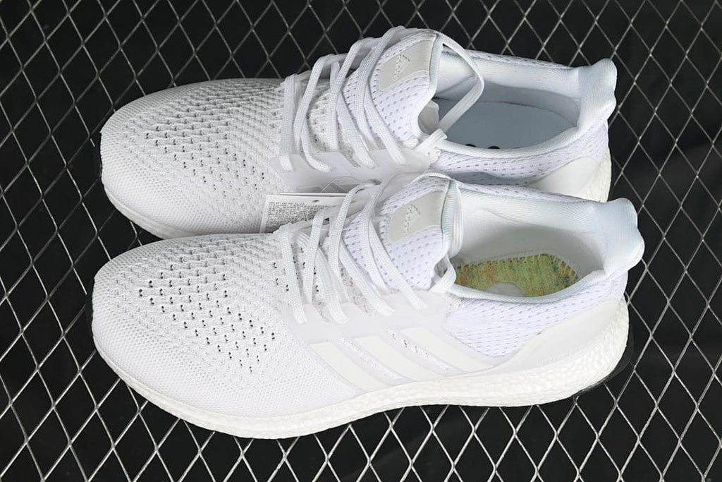 Pair of white sneakers shown from above at an angle.