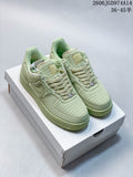 Pair of pale green low-top sneakers with woven-look panels and matching laces, shown on a white shoe box