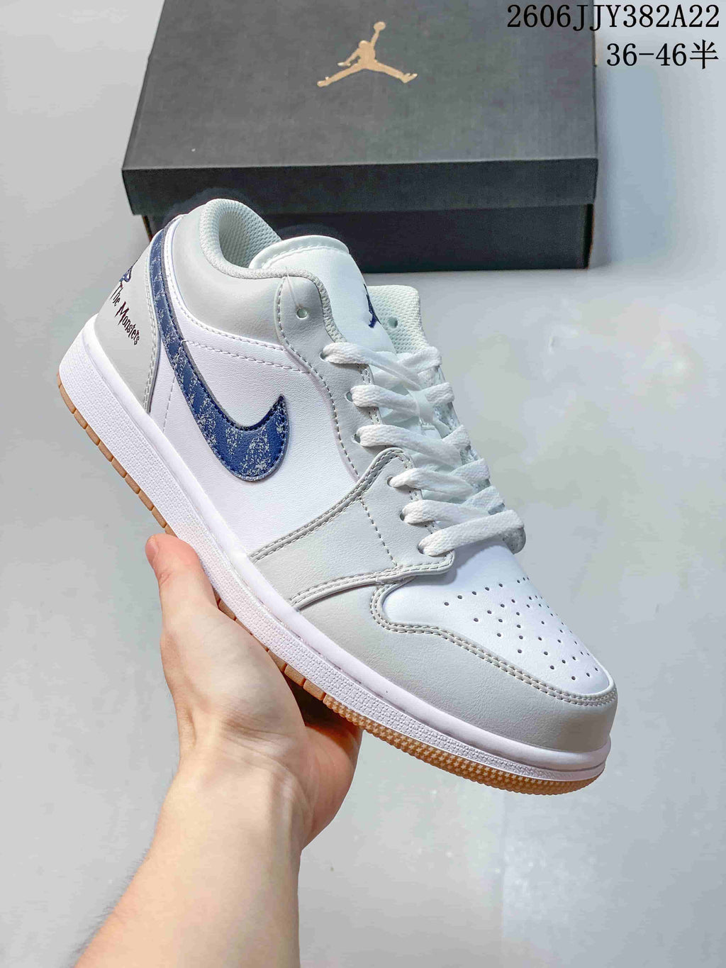 White low-top sneaker with a blue patterned Swoosh and gum-colored outsole.