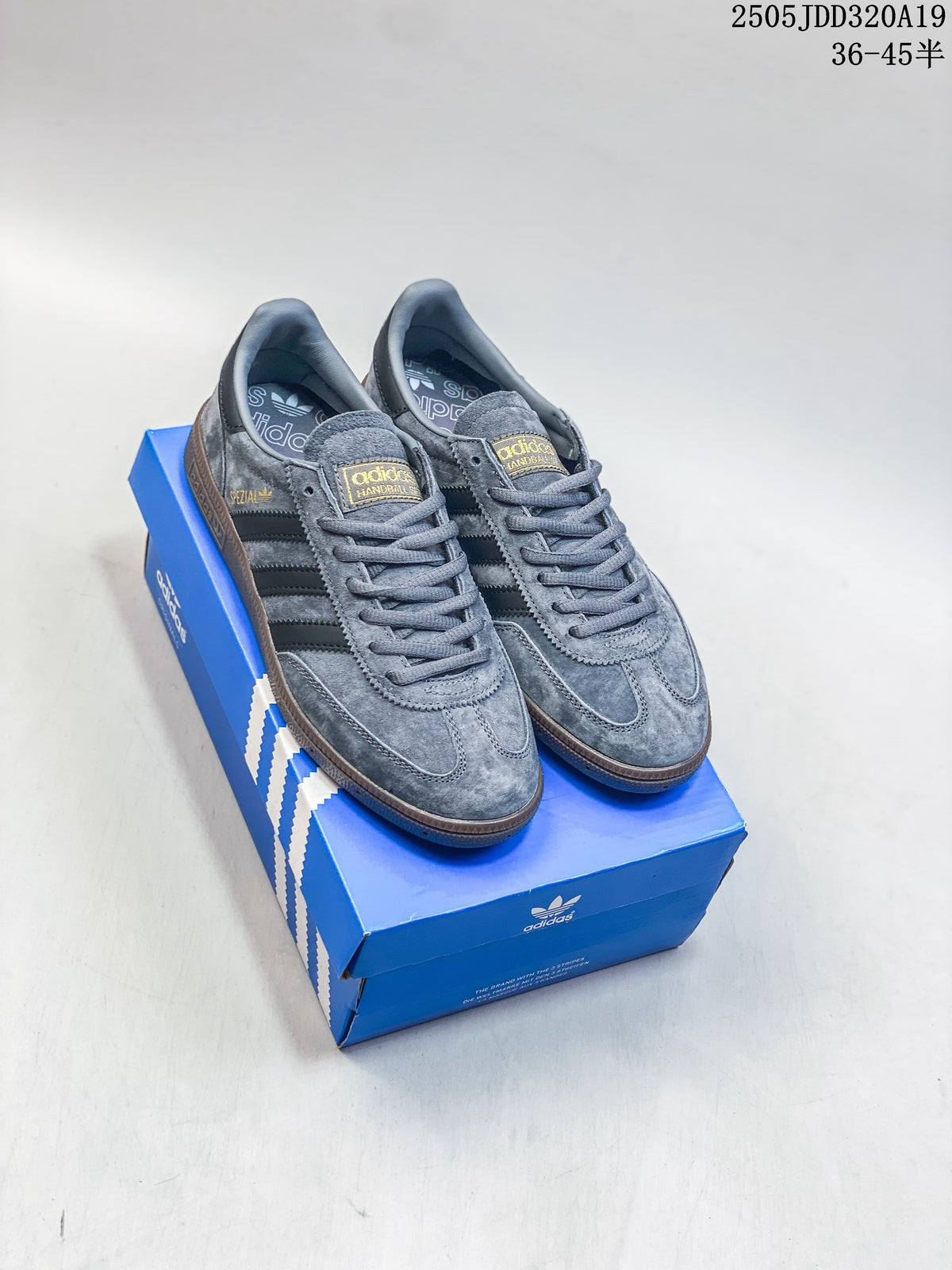 Pair of grey Adidas low-top sneakers with black stripes and brown gum-look soles, displayed on a blue shoe box.