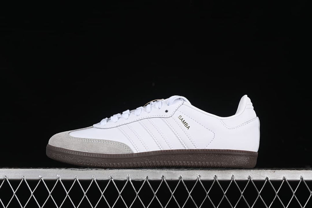 Side profile of a white adidas Samba OG sneaker with a light gray toe panel and dark gum sole