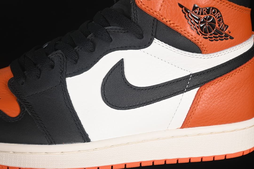 Side detail of the orange, black and white upper, Swoosh and ankle emblem