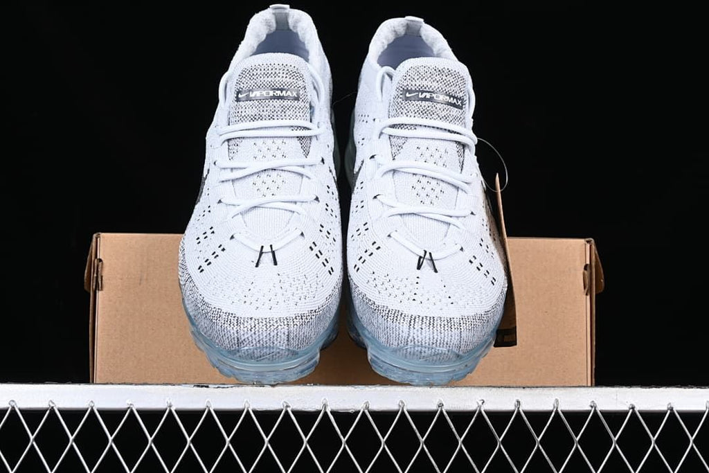 Front view of the pair of sneakers resting on a shoebox.
