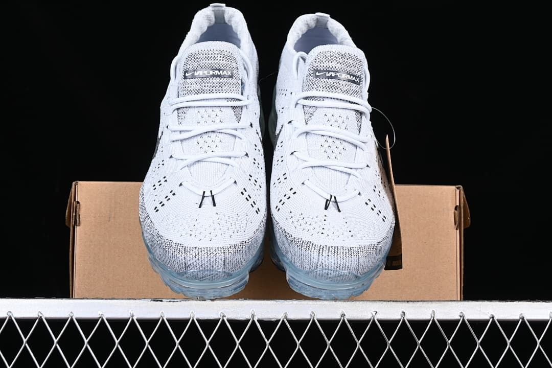 Front view of the pair of sneakers resting on a shoebox.