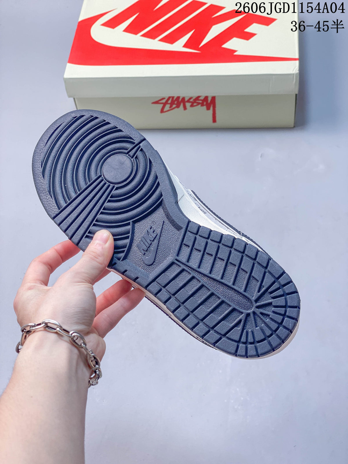 Close-up of the navy outsole on a Nike SB Dunk Low sneaker, with a branded box in the background.