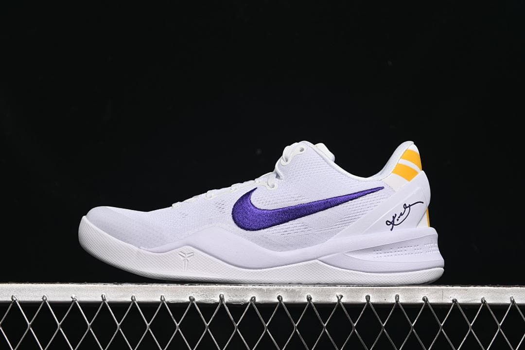 Side view of white Nike Kobe VIII Protro shoes with purple Swoosh and yellow heel accents