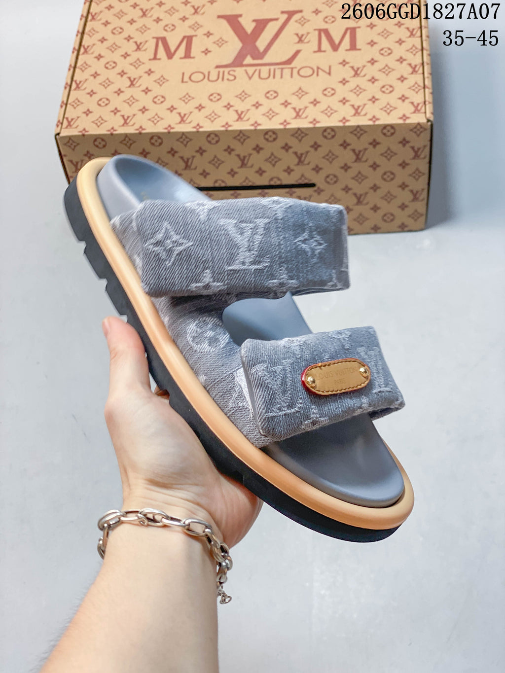 Angled view of a gray two-strap slide sandal with a contrasting layered sole.