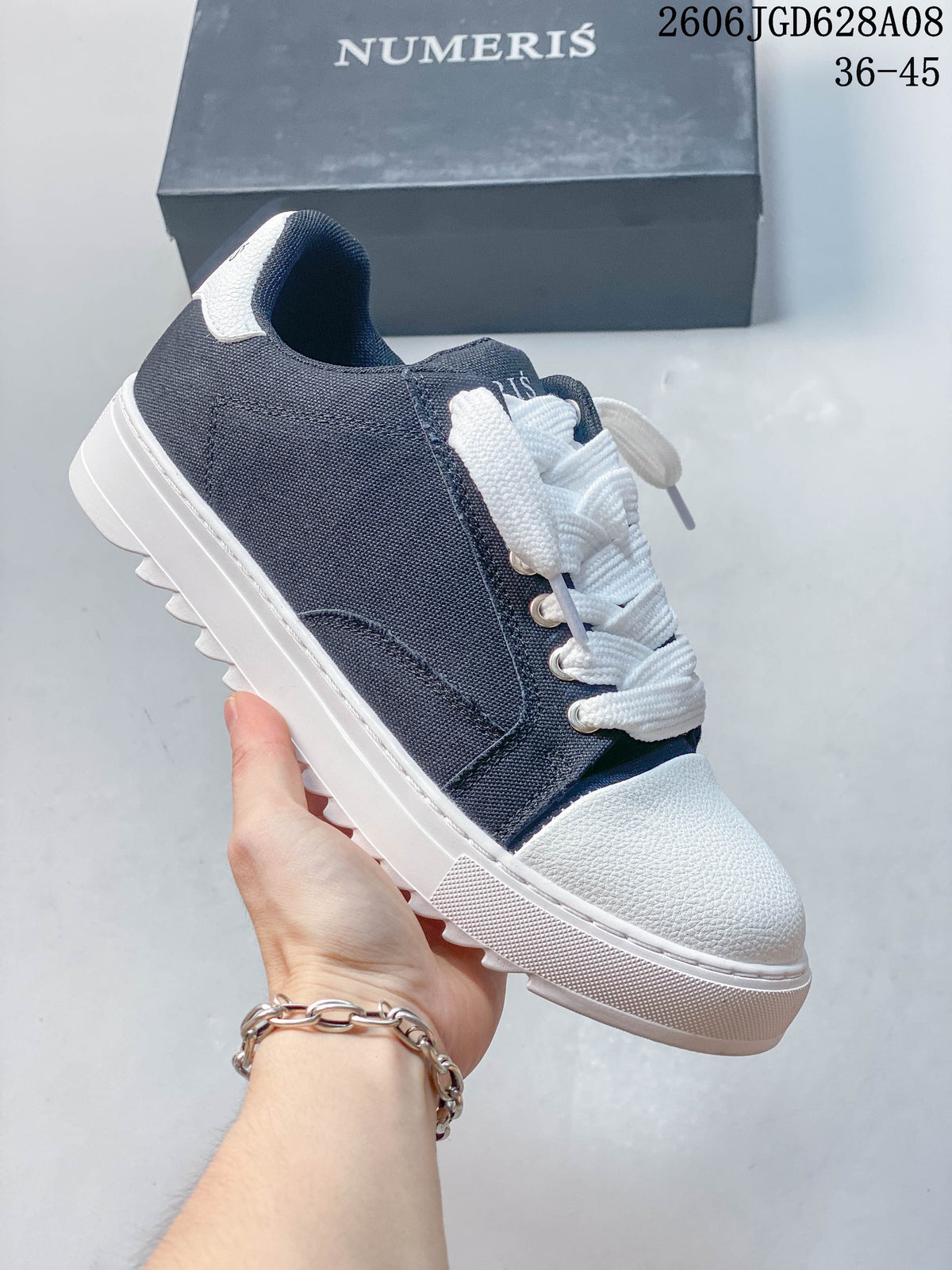 Navy low-top sneaker with a white toe and sole and plain side panels.