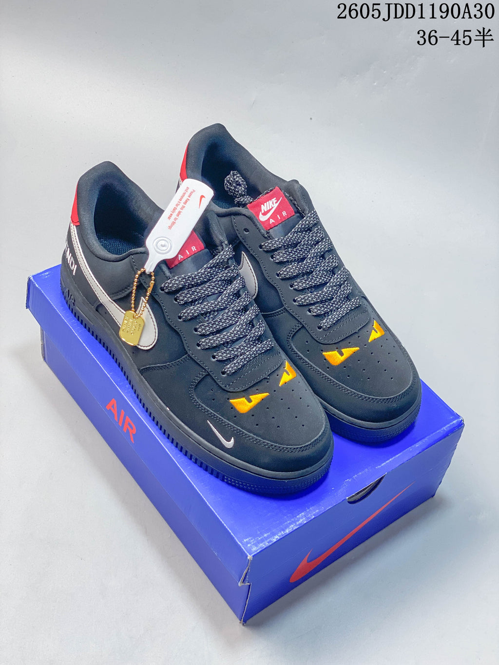 Dark gray Nike Air Force 1 '07 LV8 sneakers with white Swooshes, red and yellow accents, pictured on a blue box; image also shows a size range label.