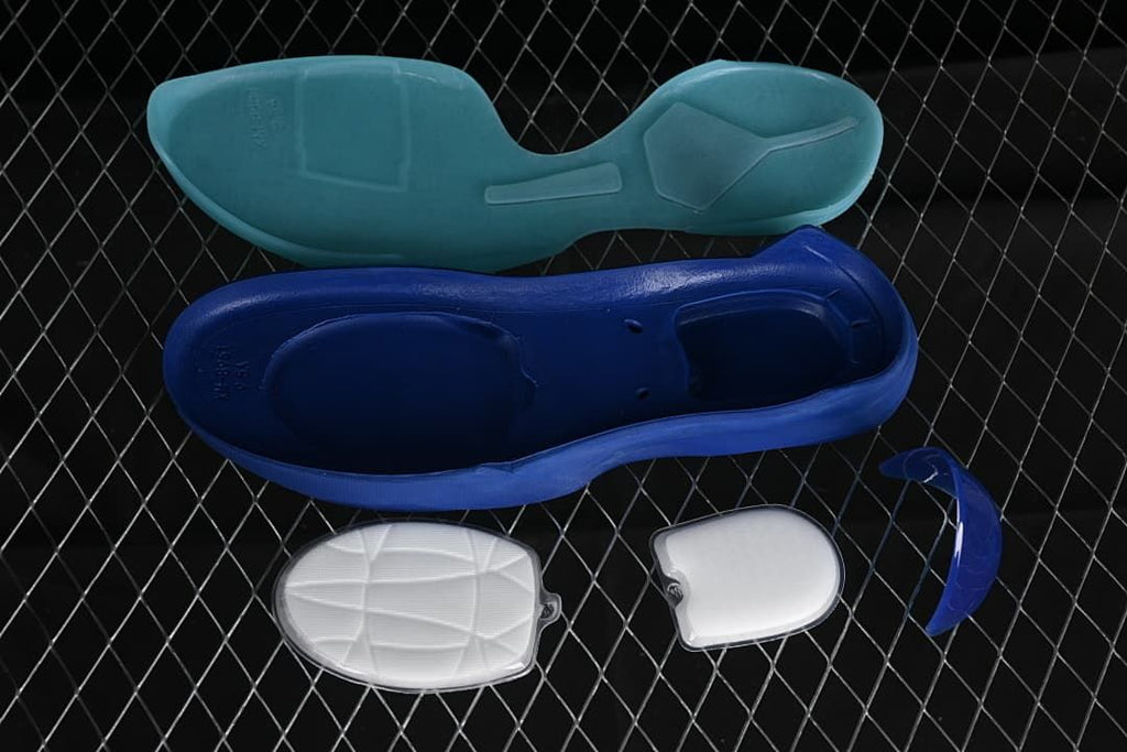 Disassembled shoe components, including blue and aqua sole sections and cushioning inserts