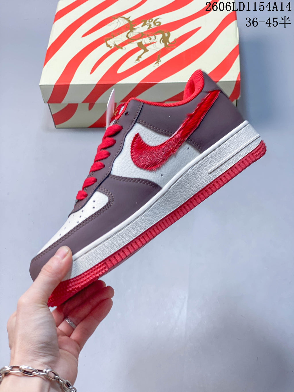 Side view of the low-top sneaker with a red Swoosh and brown and white panels.