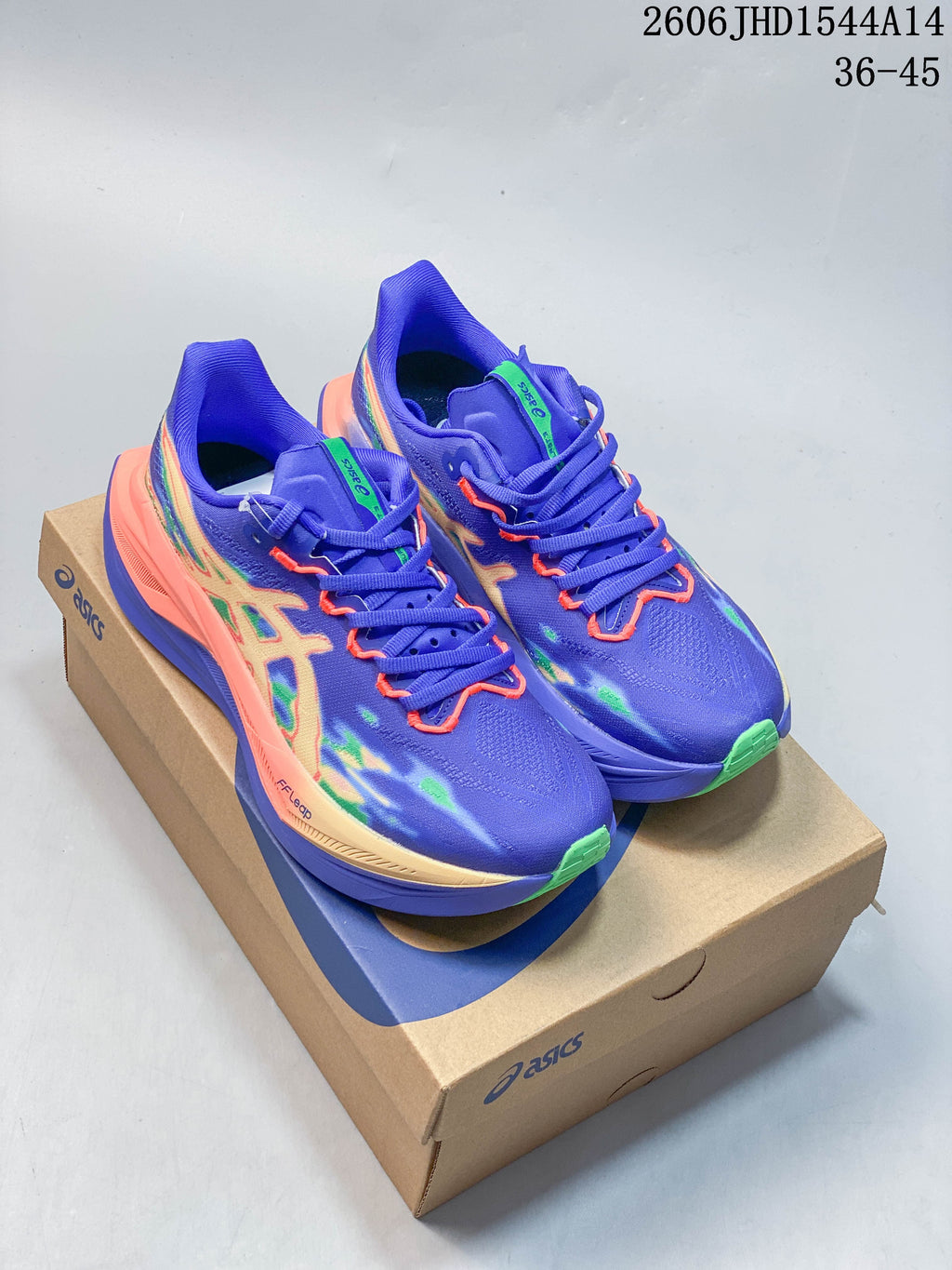 Pair of purple ASICS MEGABLAST running shoes with multicolor graphics on a shoe box