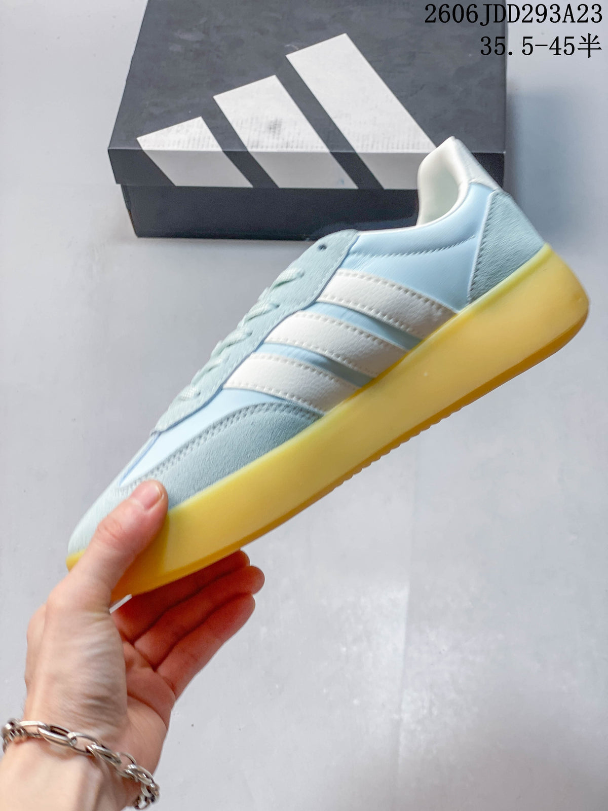 Side profile of the light blue sneaker with white stripes and yellow-toned sole