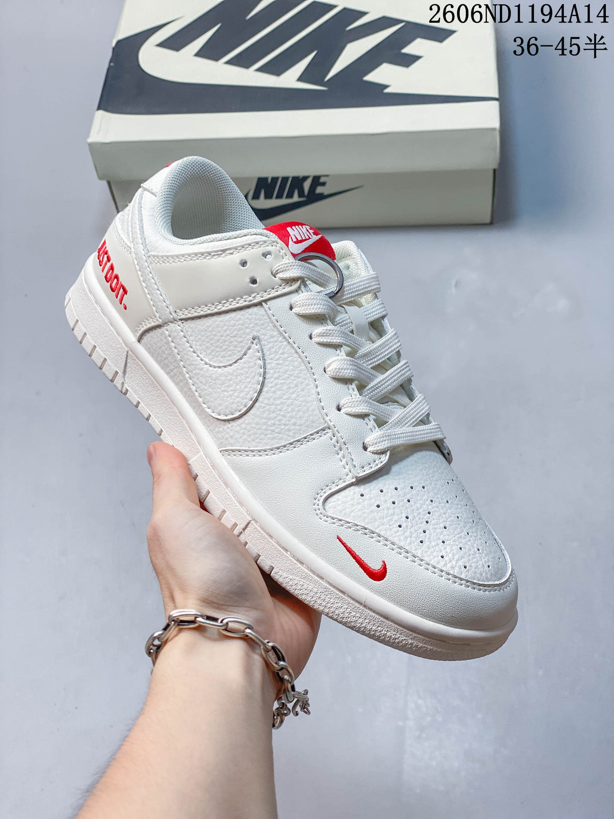 Close view of a white low-top sneaker with a red tongue label and red heel lettering.