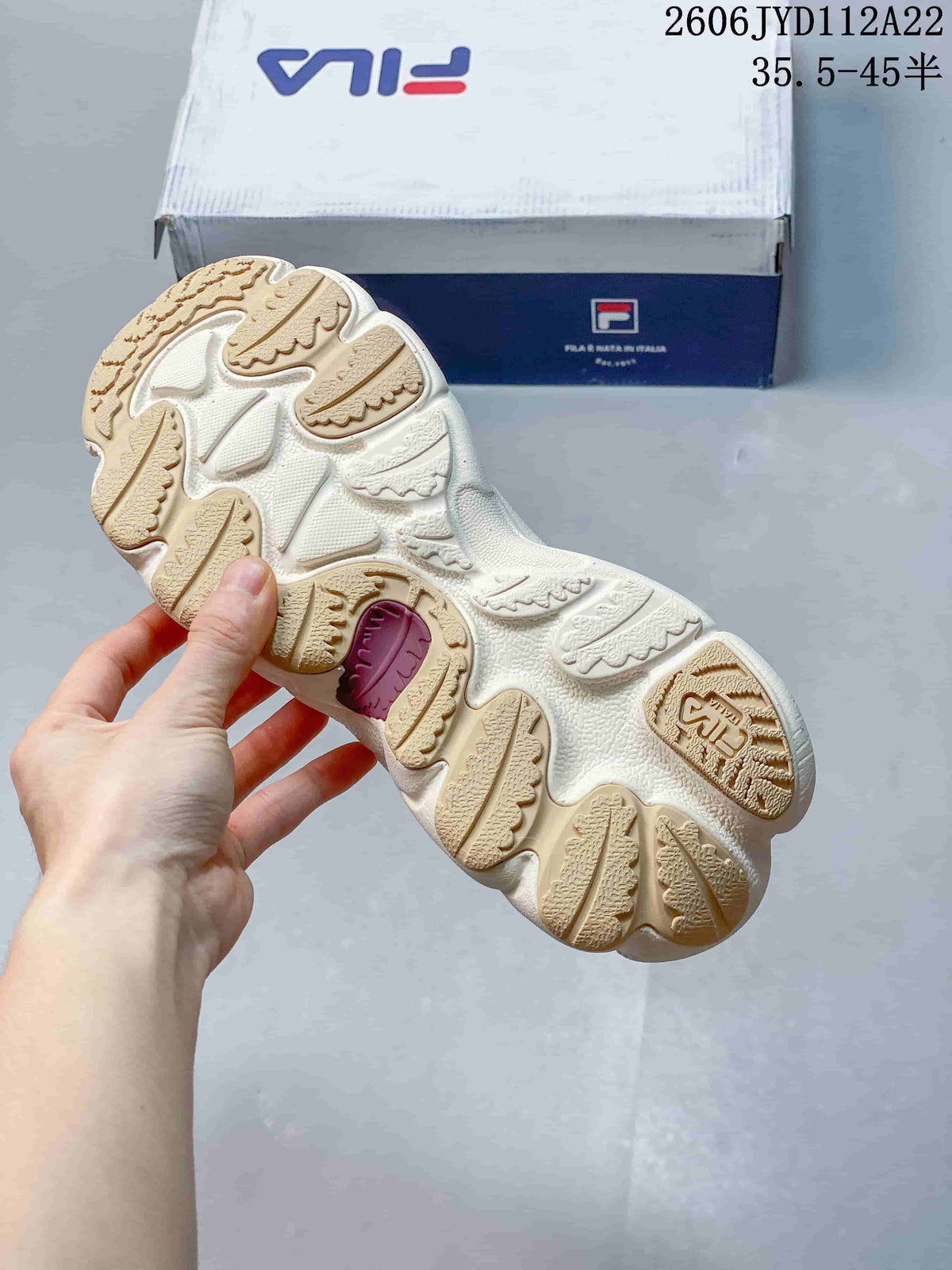 Underside of a FILA sneaker showing a patterned cream and beige outsole.