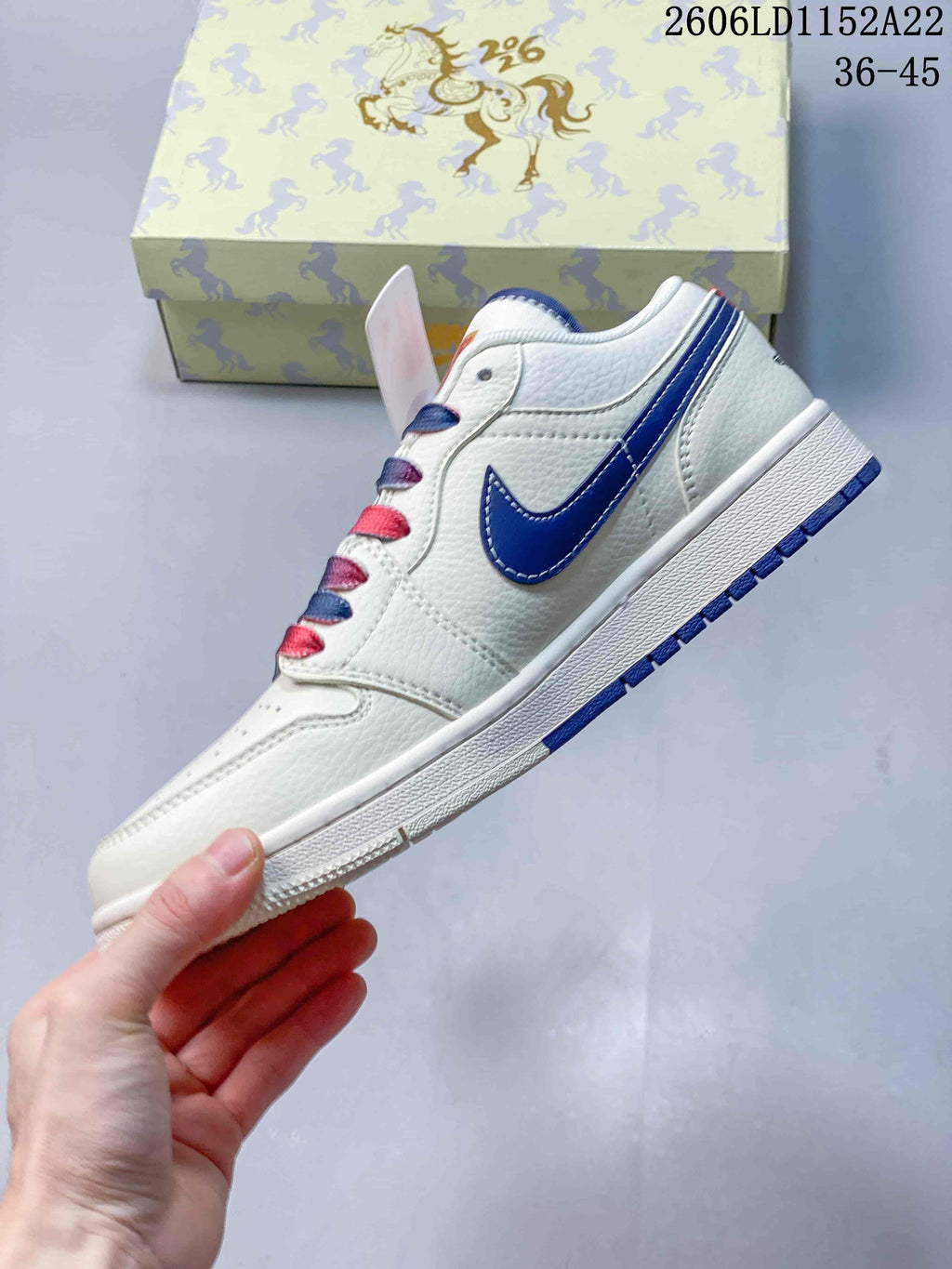 Side profile of a white low-top sneaker with a blue side logo and blue outsole accents