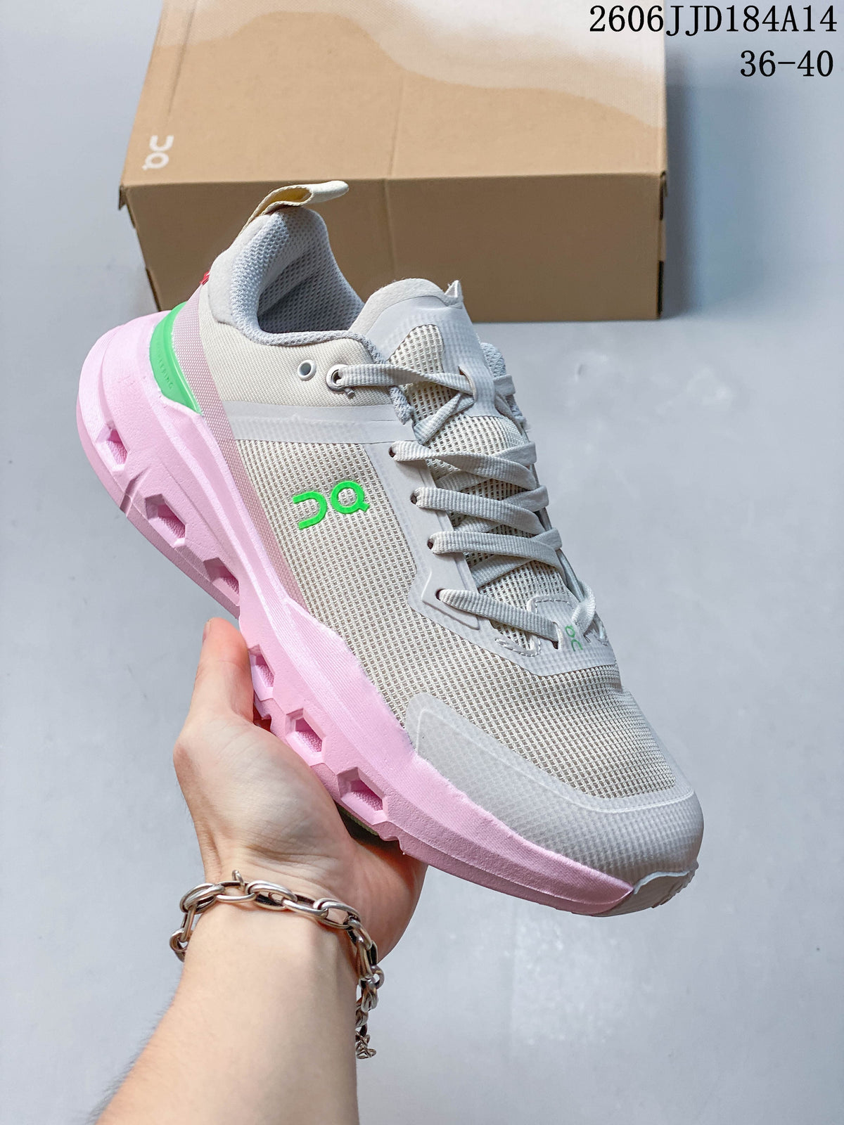 Angled view of the gray sneaker with pink sole and green logo accents