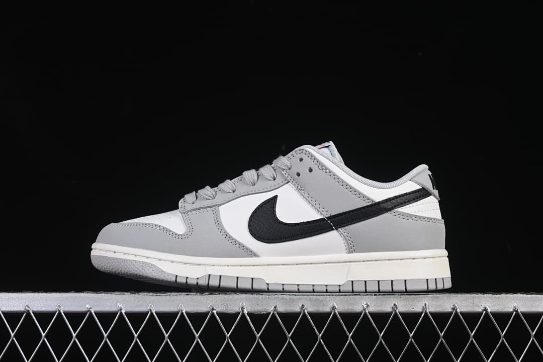 Side view of the white, grey, and black Nike Dunk Low Style sneaker