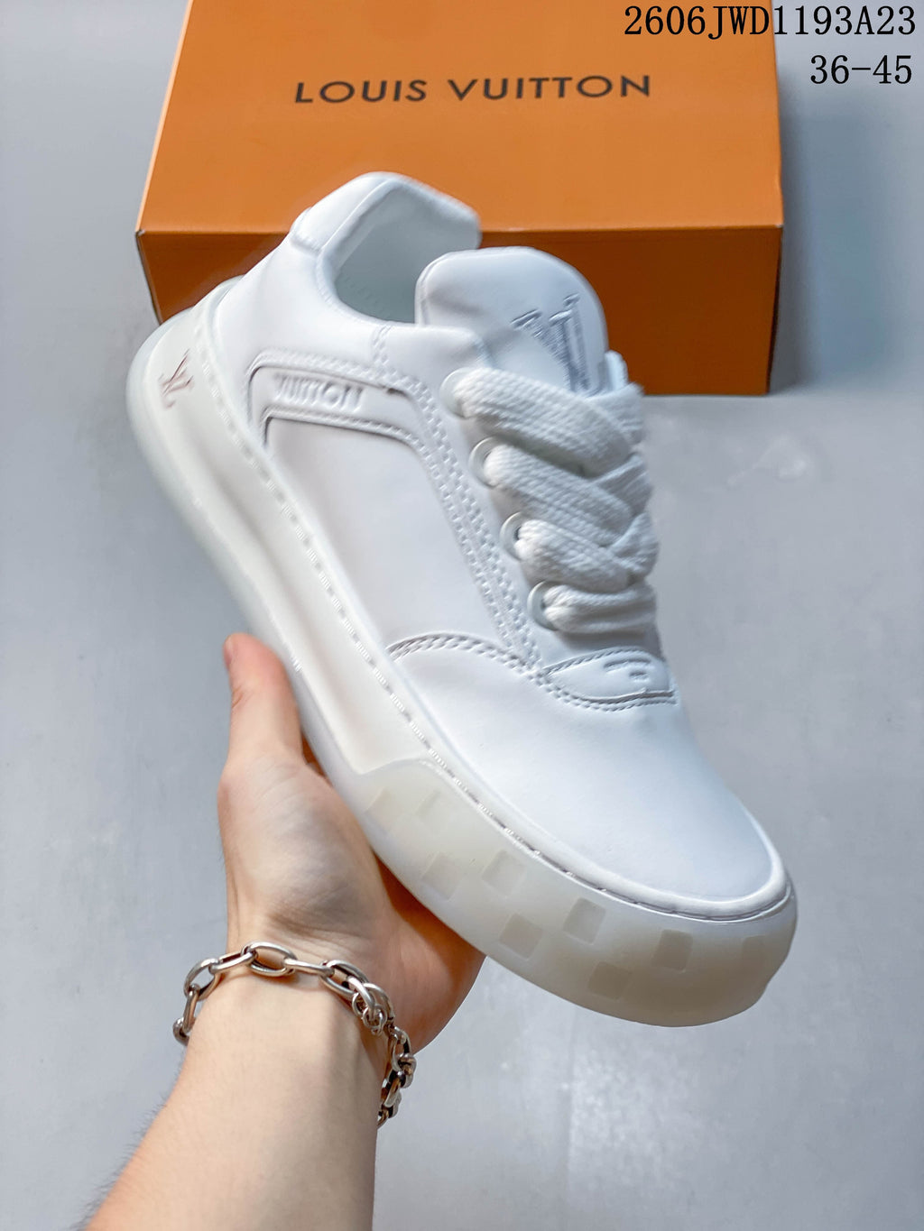 Angled view of a white low-top sneaker with stitched panels and thick sole