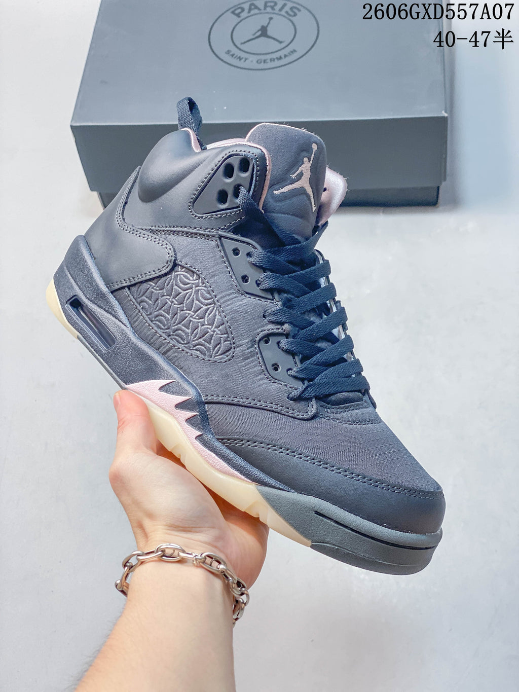 Angled side view of a gray Jordan Air Jordan 5 high-top sneaker with patterned side panel and cream outsole.