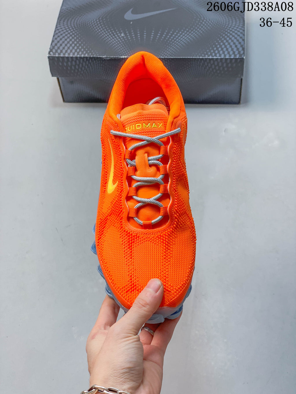 Top view of the orange lace-up shoe with gray laces and yellow tongue lettering.