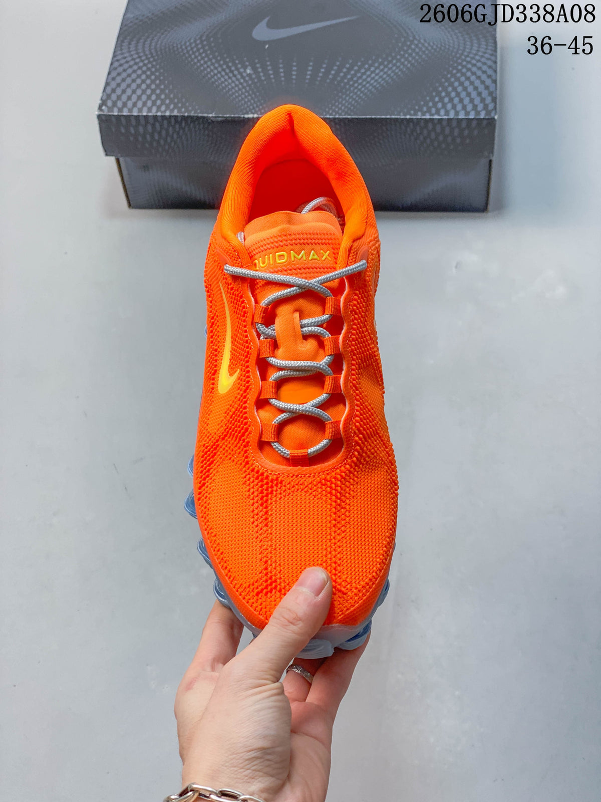 Top view of the orange lace-up shoe with gray laces and yellow tongue lettering.