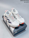 Pair of white Adidas Adizero Evo SL ATR running shoes with dark side stripes and orange accents on a shoe box